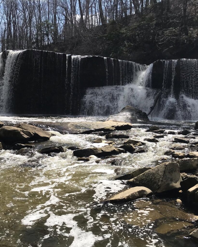 A large waterfall with water flowing over large rocks.
